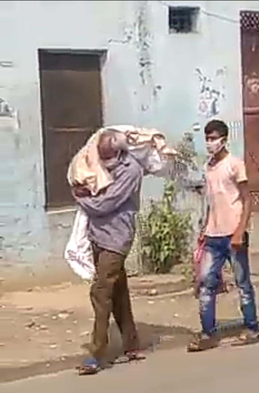 a picture embarrassing humanity, the dead body of the daughter carrying to-the-crematorium-by-the-father-on his shoulder