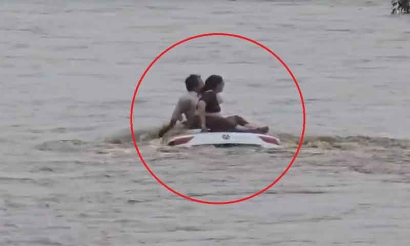 उफनती नदी के तेज बहाव में बही कार, छत पर चढ़कर बचाई जान