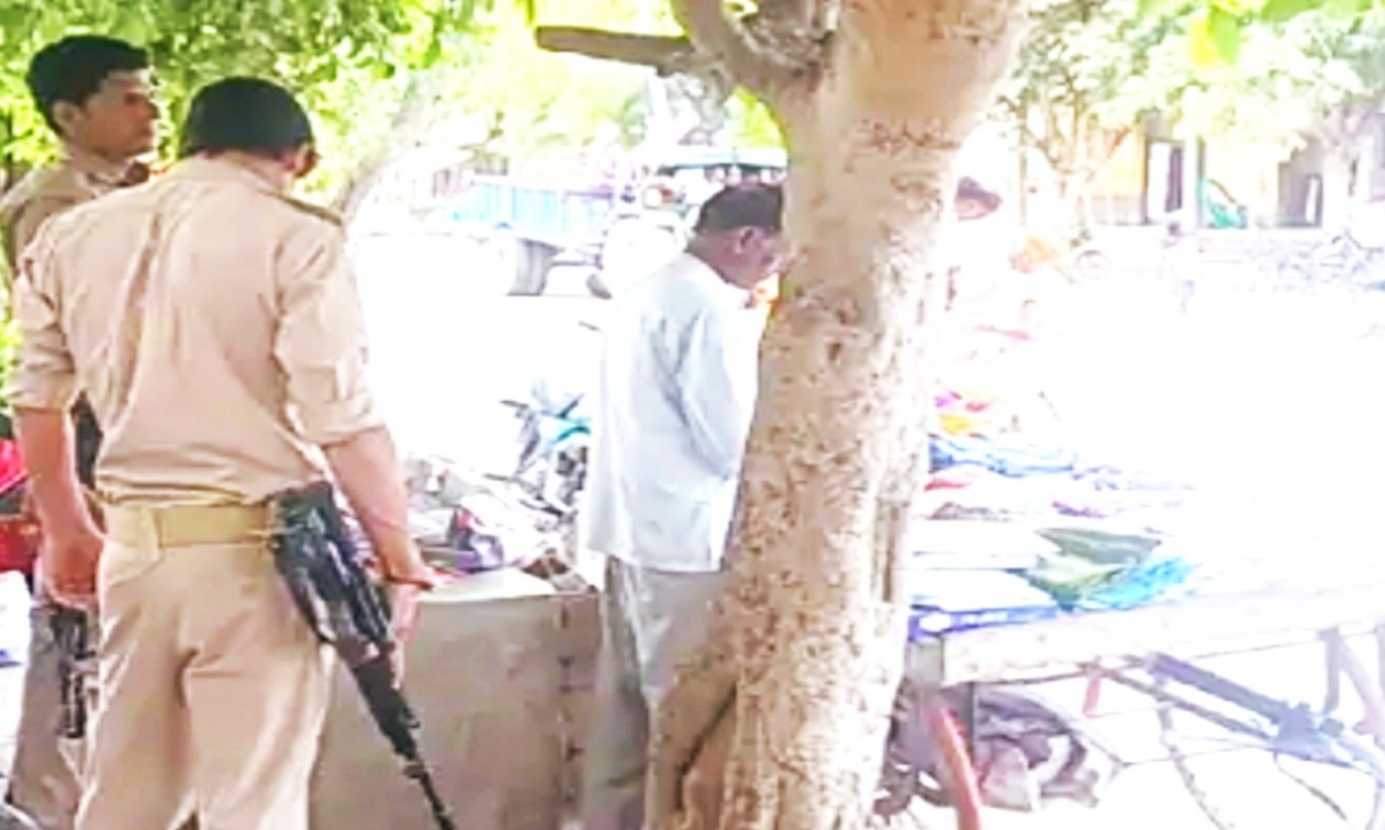You are currently viewing रेहड़ी पर कपड़े बेचने वाले की सुरक्षा में दो पुलिसकर्मी AK-47 लेकर तैनात, जानिए पूरा मामला